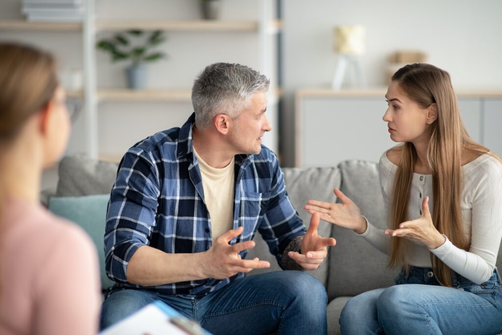 Family therapy concept. Mature married couple having argument on consultation with psychologist at